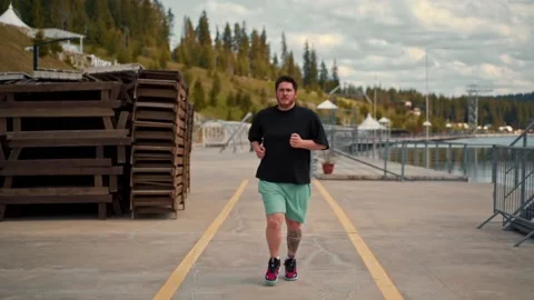 Young fat man is jogging training loses weight Stock Footage 194511417