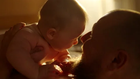 Young father with beard caressing and kissing his newborn baby kept by mother in Stock Footage 162807928