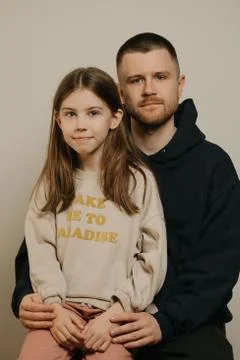A young father with a beard posing with her daughter. Family photo. Stock Photos