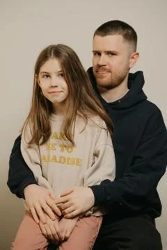 A young father with a beard posing with her daughter. Family photo. Stock Photos