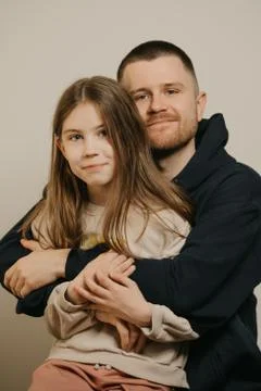 A young father with a beard posing with her daughter. Family photo. Stock Photos