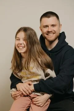 A young father with a beard posing with her daughter. Family photo. Stock Photos