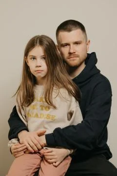 A young father with a beard posing with her daughter. Family photo. Stock Photos