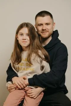 A young father with a beard posing with her daughter. Family photo. Stock Photos