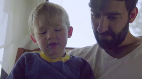 Young father with beard teachs boy to use mobile phone Stock Footage 64403022