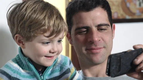 Young father with his son, videoplaying, smiling Stock Footage 59597137