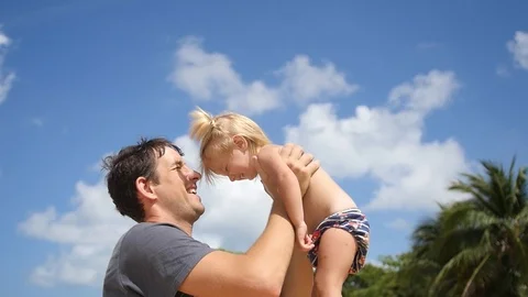 The young father joyfully throws his beloved daughter up, plays with her on the Stock Footage 88324780