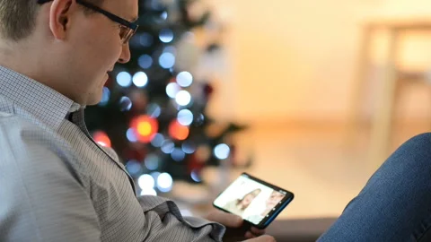 Young father making a video call with his son and daughter using smartphone Stock Footage 155996632