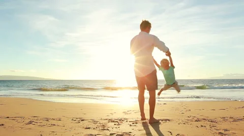 Young Father Plays With Son at the Beach at Sunset. Spinning in Circles. Stock Footage 56531387