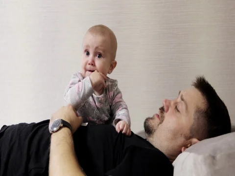 A young father with a small daughter is lying on the couch. Stock Footage 78559650