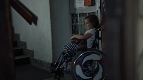 Young father taking care of his disabled child on a wheelchair Stock Footage