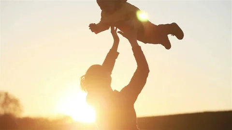 Young father throw son into air and catch him sunset nature countryside backlit Stock Footage 63299606