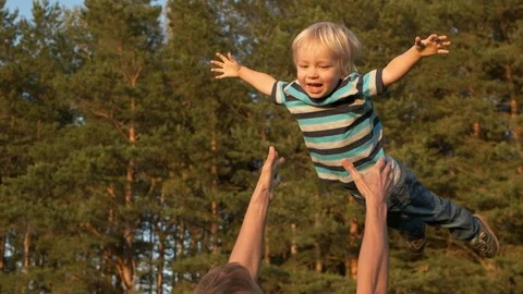 Young father throws his toddler son high up in the air. Dad and child laughing Stock Footage 115823150