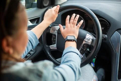 Young female aggressive driver using horn or trumpets to the another cars Stock Photos