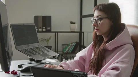 Young Female App Developer Working on Code on Multiple Devices in Office Stock Footage 335939431