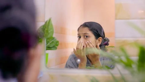 Young female checking dark circles and under eye skin in a bathroom mirror. Stock Footage 328961348