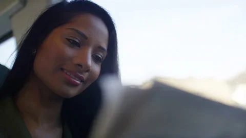 Young female checking share prices as she rides a train, in slow motion Stock Footage 83647436