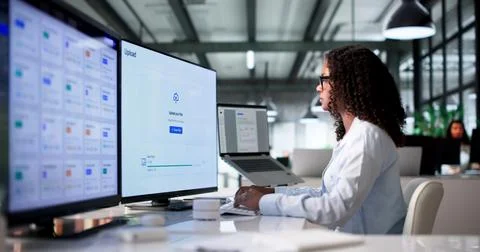 Young Female Cloud Engineer Uploads Secure Data Files Using Computer System. Stock Photos