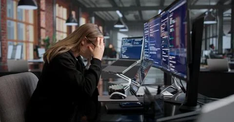 Young Female Coder Looks Frustrated While Struggling With Her Laptop Code. Fotos Stock