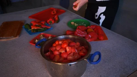 Young female cook in skeleton costume and apron cut red sweet peppers 動画素材 96736853