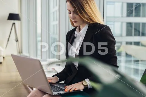 Young female copywriter writing an advertising text typing on laptop keyboard Stock Photos