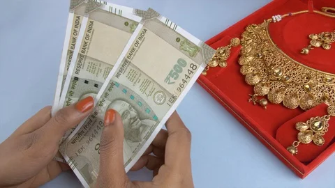 Young female counts a bundle of Indian currency notes - gold loan or gold mor... Stock Footage 128677296