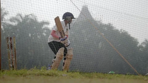A young female cricketer batting in the net practice session 動画素材 326409464