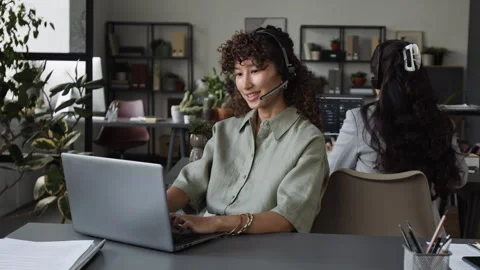 Young Female Customer Support Agent Working on Laptop in Office Stock Footage 343606743