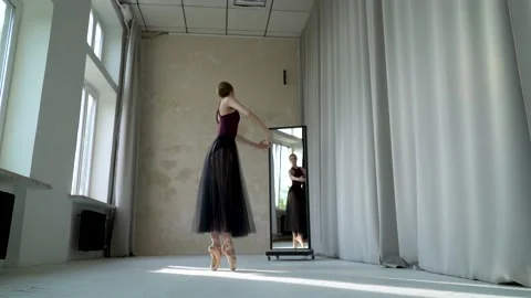 Young female dancer in does ballet exercises on the tiptoes in beige pointe Stock Footage 137392219