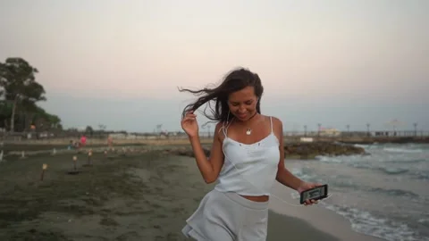 Young female dancer using smartphone, listening to music and dancing Stock Footage 131194157
