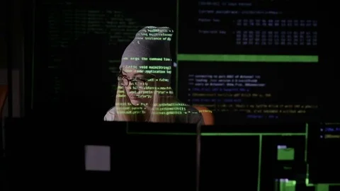 Young female in dark inputting data, computer codes, breaking security system Stockbeeldmateriaal 71270300