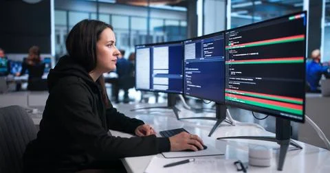 Young Female Developer Compares Code Changes On Computer Using Visual Tool. Stock Photos