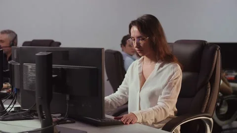 A young female developer sitting in front of a computer in an office sighs Stock Footage 235785174
