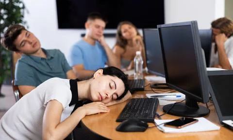 Young female developer tired after workday napping near computer Foto stock