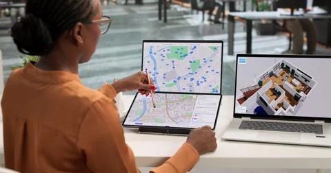 Young Female Developer Uses Touchscreen Laptop To Study Urban Land Plans. Stock Photos