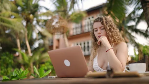 Young female developer working on laptop by the ocean. Woman freelancer coding Stock Footage 237136954