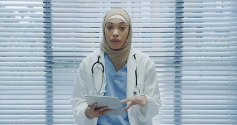 Young female doctor using tablet and talking to camera 4k Stock Footage 112038036