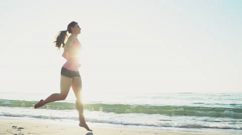 Young female does jogging on the beach slow motion Stock Footage 53897698