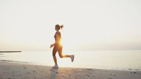 Young female does jogging on the beach slow motion Stock-Footage 54221693
