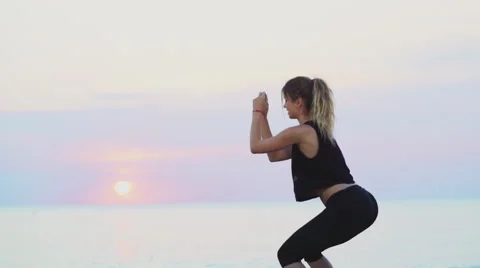 Young female does squats on the beach slow motion Stock Footage 54205659