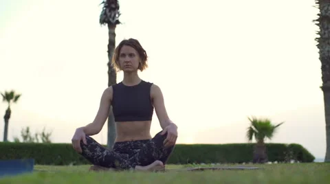 Young female doing breathing practice sitting on grass slow motion Stock Footage 63049375
