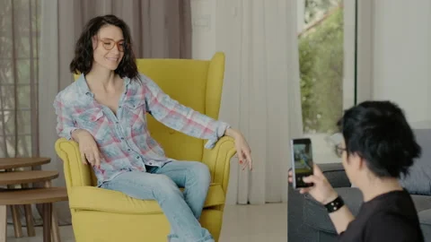 Young female doing different poses for photographer taking pictures on Stock Footage 133078686