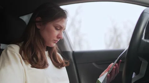 Young female driver holds a map in her hands and chooses the direction for the Stock Footage 185559839