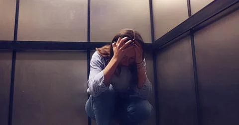 Young Female Elevator Technician Experiencing Panic Attack While Trapped Insi Stock Photos