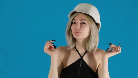 Young female engineer adjusts protective helmet on blue Stock Footage 306494564