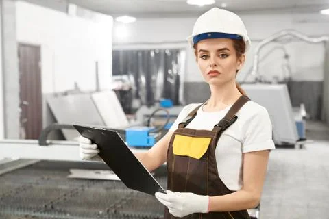 Young female engineer posing while working on metal factory 스톡 사진