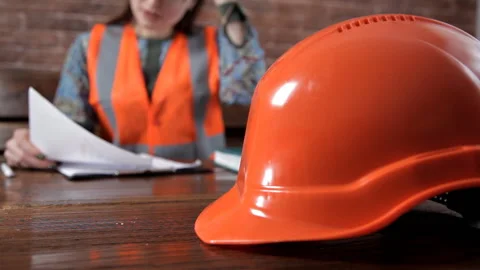 Young female engineer takes notes on work.Special uniform and helmet Stock-Footage 103493423
