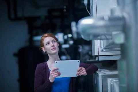 Young female engineer using a digital tablet and thinking in an industrial plant Stock Photos