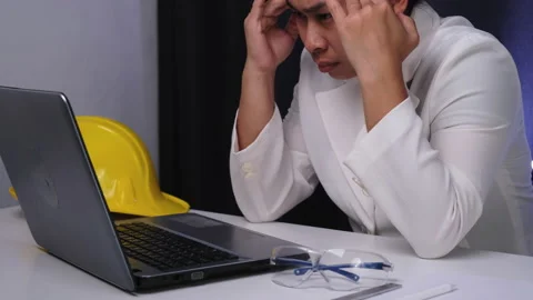Young female engineer working on laptop, analyzing data in documents in office. Stock Footage 237501587