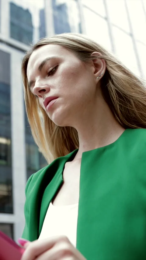 Young female executive browsing her tablet in a modern city Stock Footage 346369068